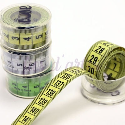 Quatro rolos de fita métrica coloridos com números pretos em suporte plástico