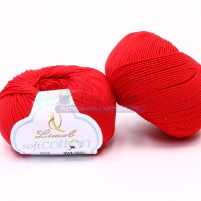 Novelos de fio vermelho com etiqueta 'Lusansoft Soft Cotton' sobre fundo branco