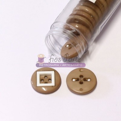 Botões de plástico bege com quatro furos em tubo transparente aberto sobre fundo branco