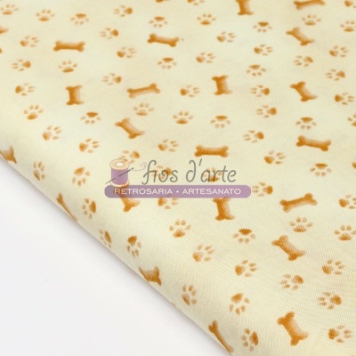 tecido bege claro com padrão de ossos e pegadas de cachorro em tons castanho claro