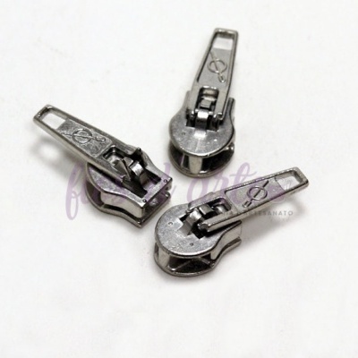 Três puxadores metálicos de fecho éclair prateados sobre fundo branco