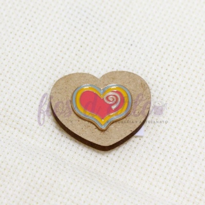 Íman coração de madeira com pintura colorida sobre tecido branco de quadrados pequenos