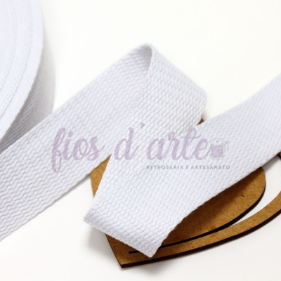Fita branca em tecido com textura ondulada sobre etiqueta de cartão castanho