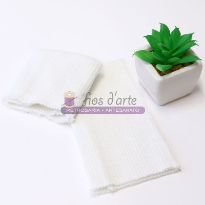 Pedaços de tecido branco canelado ao lado de vaso com planta verde artificial.