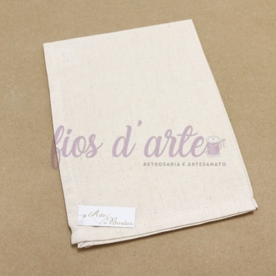 Toalha de tecido cru com etiqueta e texto impresso sobre fundo bege