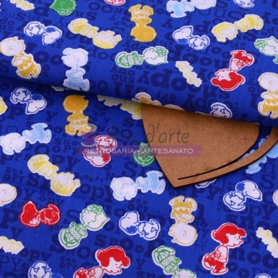 Tecido azul com padrão colorido de personagens tipo Snoopy e sombra de papel castanho