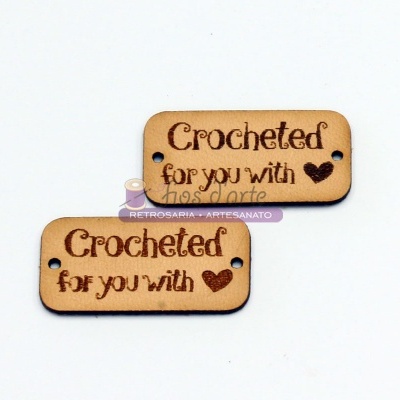Etiqueta de madeira com texto gravado 'Crocheted for you with' e coração