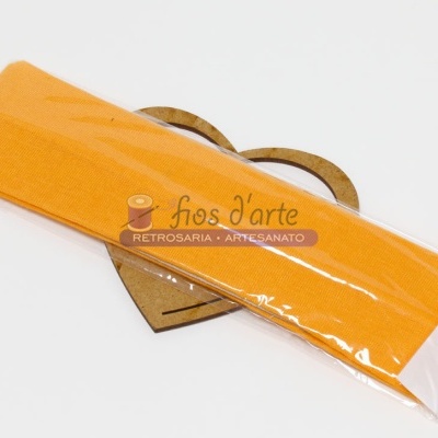 Fita amarela embalada em plástico com etiqueta 'fios d'arte' sobre coração de madeira