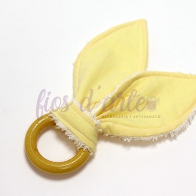 Chocalho de madeira com tecido amarelo em forma de folhas