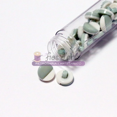 Comprimidos redondos verde e branco em frasco transparente sobre fundo branco