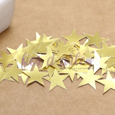 Estrelas douradas de papel metálico sobre superfície castanha