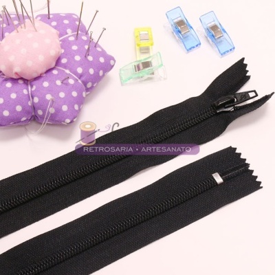 Fechos éclair pretos, almofada de alfinetes roxa e molas de costura coloridas