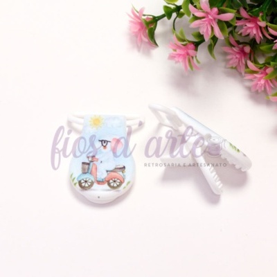 Dois clips decorativos com desenho de coelho azul e scooter cor-de-rosa sobre fundo branco com flores cor-de-rosa