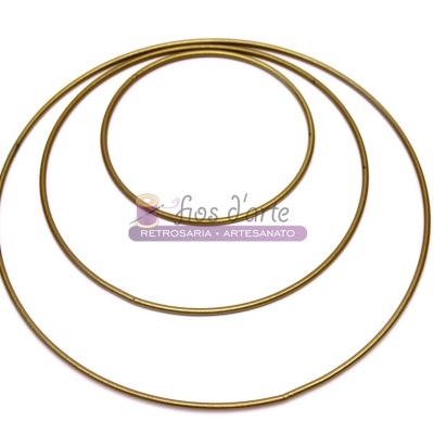 Três aros metálicos dourados de tamanhos variados sobre fundo branco