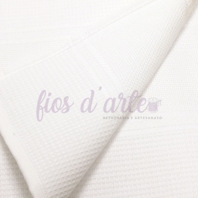Toalha branca texturizada dobrada sobre superfície clara