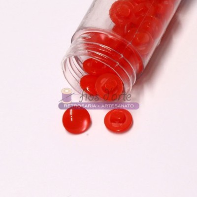 Frasco transparente com botões vermelhos redondos e brilhantes em fundo branco