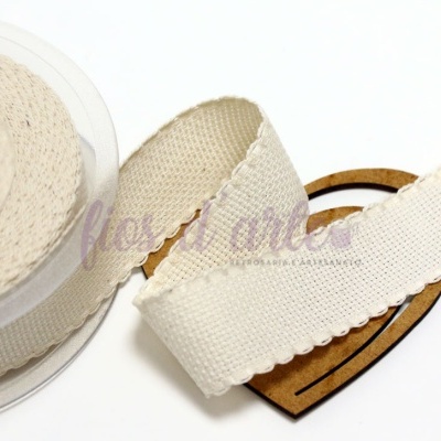 Fita de tecido bege claro com bordas onduladas em rolo com etiqueta de cartão