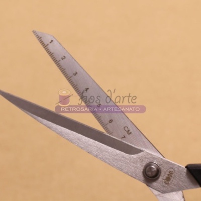 Tesoura metálica com cabo preto e régua transparente com escala em centímetros