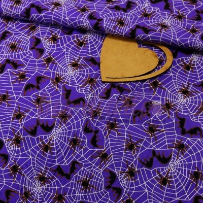 Tecido roxo com padrão de teias de aranha, morcegos e aranhas em preto e branco, com um recorte em forma de coração de madeira
