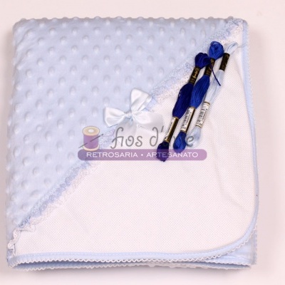 Manta azul clara com textura de bolinhas e novelos de linha azul