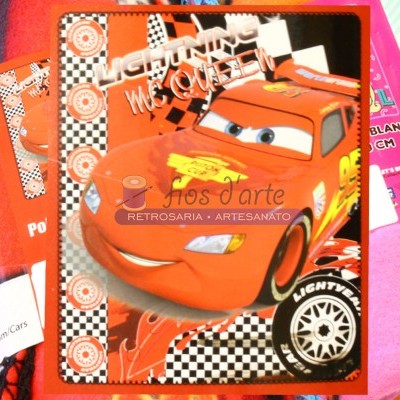 Embalagem de manta infantil com imagem do carro relâmpago McQueen vermelho.
