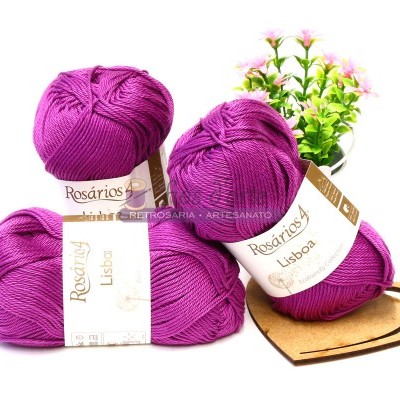 Novelos de lã roxa com etiquetas Rosários 4 Lisboa junto a planta decorativa