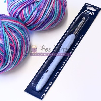 duas bolas de lã colorida e uma agulha de croché em embalagem preta