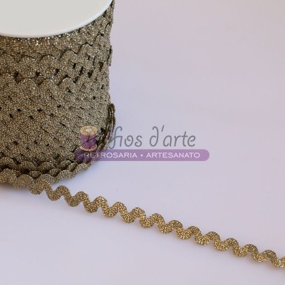 Fita decorativa ondulada dourada com brilho sobre superfície clara