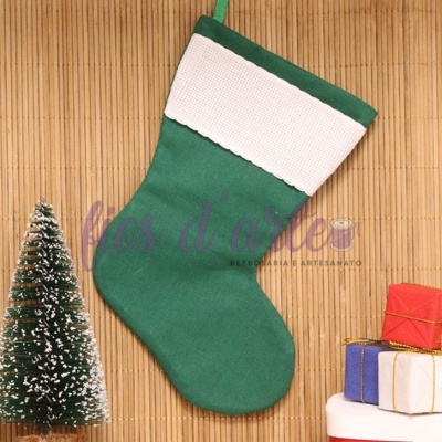 Meia de Natal verde com punho branco pendurada e presentes ao lado