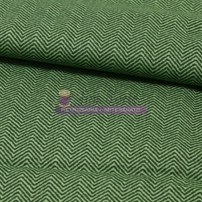 Tecido verde com padrão zig-zag branco e etiqueta colorida com texto impresso