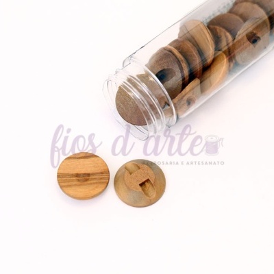 Botões redondos de madeira clara dentro de tubo plástico transparente