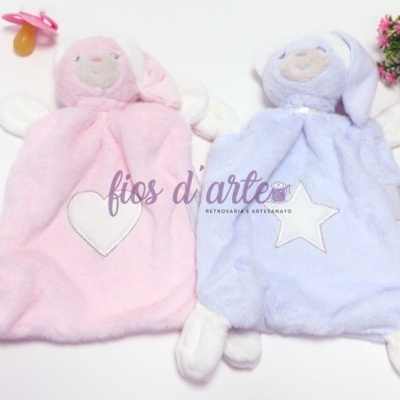 Brinquedos de pelúcia rosa e azul com corações e estrelas, biberões e vaso de flores