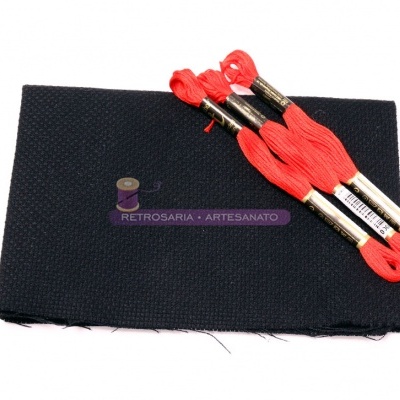 Tecido preto com três novelos de linha vermelha para bordado