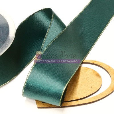 Fita de cetim verde com bordas douradas sobre superfície clara com objeto oval de madeira