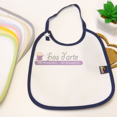 Babete branco com borda azul escura e babetes coloridos, decoração de coração em madeira e planta verde