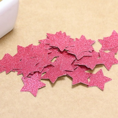 Estrelas decorativas rosas com brilho sobre superfície castanha