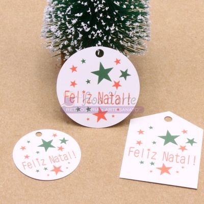 Etiquetas de Natal em papel com estrelas verdes e vermelhas e texto Feliz Natal!! em fundo castanho