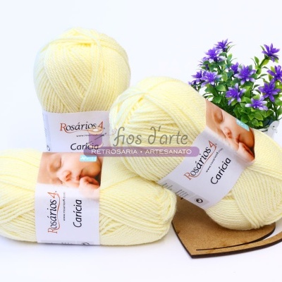 Três novelos de lã amarela clara Rosários 4 Carícia com planta com flores roxas