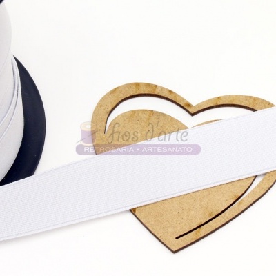 Fita elástica branca sobre base de coração em madeira.