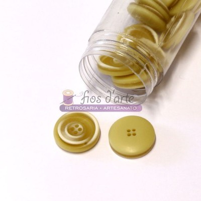 Frasco transparente com botões amarelos em dois modelos diferentes sobre superfície branca.