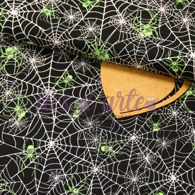 Tecido preto com padrão de teias de aranha brancas e aranhas verdes.