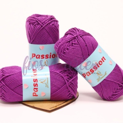 Três novelos de lã violeta com rótulo azul claro 'Passion' sobre fundo branco