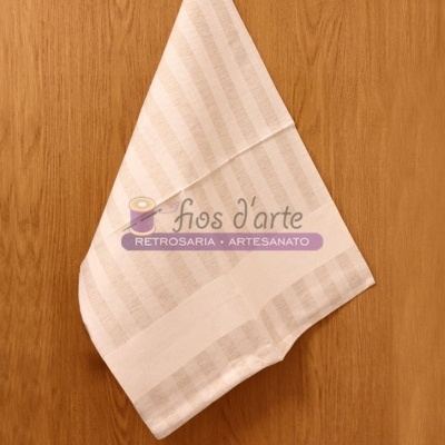 Toalha branca com riscas pendurada em parede de madeira