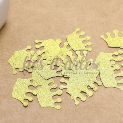 Coroas douradas em glitter em superfície castanha com recipiente branco