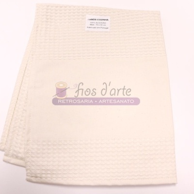 Toalha de banho creme com etiqueta branca em fundo branco