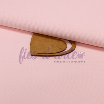 Tecido cor-de-rosa claro dobrado sobre cartão castanho