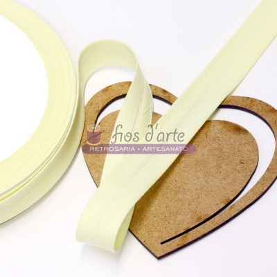 Fita amarela clara em rolo sobre corações de madeira