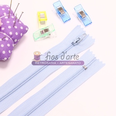Fechos éclair azuis claros com grampos coloridos e alfineteiro roxo de bolinhas