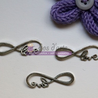 Pendentes metálicos com palavras e símbolo do infinito junto a flor de crochê roxa