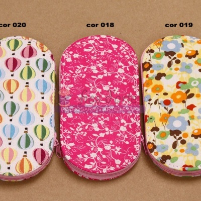 Três neceseres coloridos com padrões de balões e flores